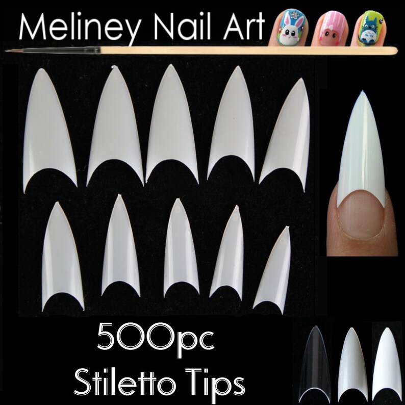 Puede incluir: Colecci&oacute;n de puntas de u&ntilde;as stiletto blancas, con una u&ntilde;a de muestra en un dedo. La imagen incluye el texto "Meliney Nail Art" y "500pc Stiletto Tips". Las puntas de las u&ntilde;as se muestran sobre un fondo negro.
