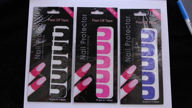 May include: Three packs of nail protector peel-off tape. Each pack has a black background with white text that reads "Nail Protector for Nail Art Painting" and "Peel Off Tape". The packs show a finger with pink, purple, and white nail polish, with the tape applied to the finger.