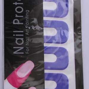 May include: A pack of purple peel-off tape for nail art. The pack has a black background with the text "Nail Protector" and "Peel Off Tape". The tape is in a sheet with 10 pieces. The pack also includes the text "For Nail Art Painting" and "10 pcs in 1 sheet".