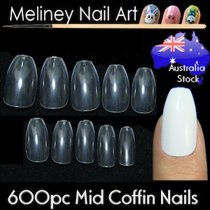 May include: 600 clear plastic coffin shaped false nails. The nails are arranged in rows of six. The nails are shown on a black background. The image also shows a finger wearing a white coffin shaped false nail.