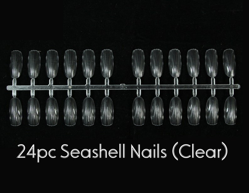 Op de afbeelding: Een set van 24 transparante, schelpvormige kunstnagels, gerangschikt in twee rijen op een plastic strip.  24pc Seashell Nails (Clear)
