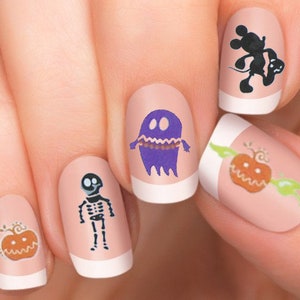 Puede incluir: Cinco u&ntilde;as con arte de u&ntilde;as de tem&aacute;tica de Halloween. Los dise&ntilde;os incluyen un fantasma, un esqueleto, una calabaza y un personaje de Mickey Mouse.