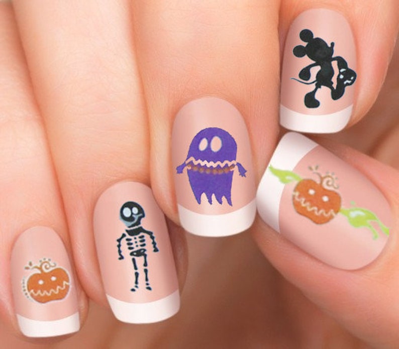 Puede incluir: Cinco u&ntilde;as con arte de u&ntilde;as de tem&aacute;tica de Halloween. Los dise&ntilde;os incluyen un fantasma, un esqueleto, una calabaza y un personaje de Mickey Mouse.