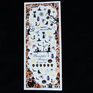 Puede incluir: Pegatinas de arte de u&ntilde;as de Halloween con im&aacute;genes de gatos, calabazas, fantasmas, murci&eacute;lagos, ara&ntilde;as, sombreros de bruja y un cementerio. Las pegatinas est&aacute;n sobre un fondo blanco con un dise&ntilde;o de llamas naranja y negro.