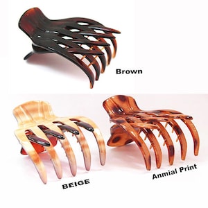 May include: Three claw hair clips in brown, beige, and animal print. The clips are made of a glossy material and have multiple curved teeth for securing hair. The word "Brown", "Beige", and "Anmial Print" are printed on the image.