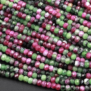 Peut inclure: Un brin de perles de pierres précieuses facettées vertes et roses. Les perles sont petites et rondes, et elles sont enfilées sur un fil transparent. Les perles sont un mélange de vert et de rose, et elles ont une finition brillante et polie.