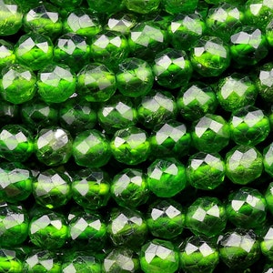 Peut inclure: Un brin de perles de verre vertes facettées. Les perles sont rondes et ont une finition brillante et irisée.