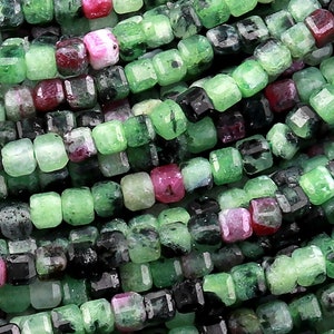 Może przedstawiać: Szereg zielonych, czarnych i różowych koralików z kamieni szlachetnych. Koraliki mają kwadratowy kształt i fasetowane wykończenie.