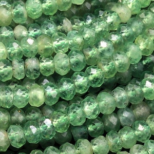 Peut inclure: Un brin de perles de pierres précieuses facettées vertes. Les perles sont rondes et ont une finition lisse et polie.