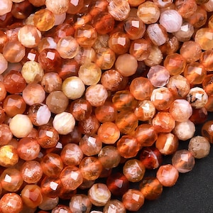Peut inclure: Un brin de perles de cornaline orange, jaune et rose. Les perles sont facettées et ont une forme naturelle irrégulière.
