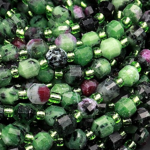 May include: A close-up of a strand of green gemstone beads with black and red accents. The beads are faceted and have a natural, rough texture.