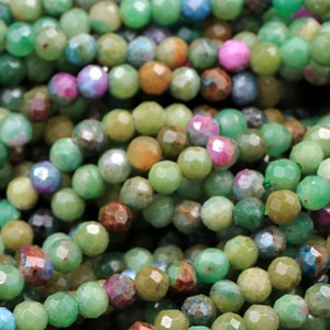 May include: A strand of green, faceted gemstone beads. The beads are small and have a variety of colors, including green, blue, and brown.
