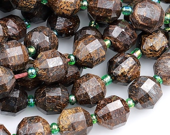 May include: A strand of brown faceted gemstone beads with green accents. The beads are oval shaped and have a rough, natural texture.