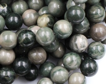 May include: A collection of round, polished beads in varying shades of forest green, sage, and muted gray. Each bead features unique natural marbling and swirling patterns, creating a textured appearance across the entire group of spherical stones.