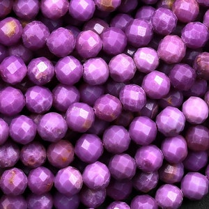 May include: A strand of purple faceted gemstone beads. The beads are round and have a smooth, polished finish.
