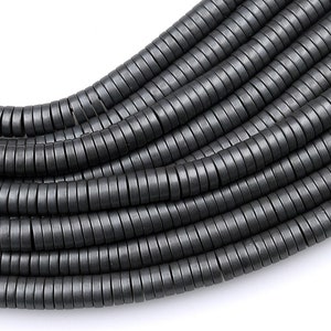 May include: A strand of black hematite beads, each bead is a small ring, the beads are stacked and coiled together.