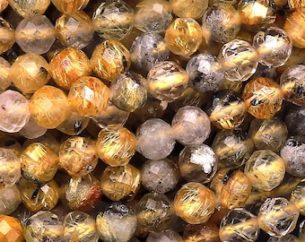 May include: A strand of faceted golden rutilated quartz beads. The beads are translucent and have a golden shimmer. The beads are approximately 6mm in diameter.