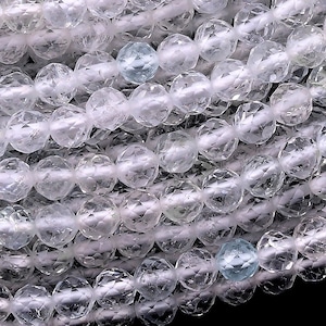 May include: A strand of clear faceted crystal beads. The beads are round and have a slightly iridescent sheen.