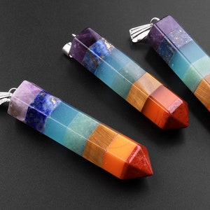 May include: Four chakra crystal pendants with silver caps. Each pendant is a layered, multi-colored, pointed crystal with a rainbow of colors, including red, orange, yellow, green, blue, indigo, and violet.