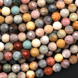 May include: A close-up of a strand of multi-coloured gemstone beads. The beads are faceted and have a variety of colours, including brown, pink, green, and grey.
