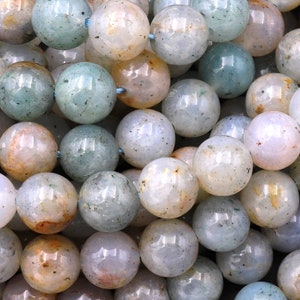 Pode incluir: Um fio de contas redondas, lisas, azul claro, branco e marrom de &aacute;gata. As contas t&ecirc;m um aspecto salpicado, nublado e transl&uacute;cido.