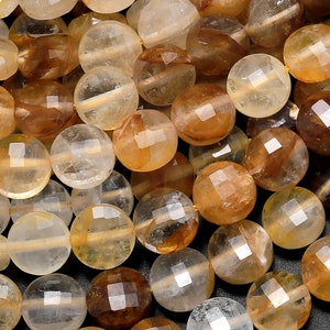 May include: A strand of round, faceted, translucent beads in shades of clear, golden yellow, and brown. The beads are made of natural citrine quartz.