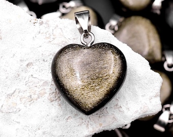 May include: A gold and black heart-shaped pendant with a silver chain. The pendant is made of a natural stone with a shimmering, iridescent finish.