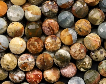 Puede incluir: Primer plano de una hebra de cuentas redondas y facetadas de piedras preciosas. Las cuentas son una mezcla de colores marrón, verde y gris con una variedad de patrones.