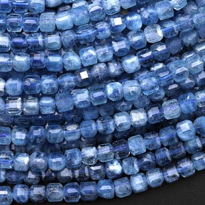 May include: A strand of blue apatite beads, each bead is faceted and has a square shape.