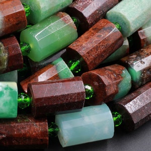 May include: A close-up of a strand of green and brown gemstone beads. The beads are faceted and have a polished finish. The beads are strung on a clear thread.
