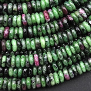 Op de afbeelding: Een streng groene, roze en zwarte edelsteen kralen. De kralen zijn rond en hebben een gladde, gepolijste afwerking. Ze zijn geregen op een doorzichtige draad.