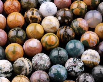 May include: A collection of round, multi-colored agate beads with brown, green, white, and pink patterns. The beads are smooth and polished.