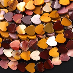 May include: A collection of heart-shaped stones in various colors, including shades of yellow, orange, red, brown, and purple. The stones are smooth and polished, with natural variations in color and pattern. The hearts are of varying sizes.