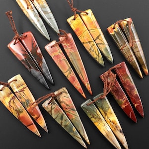 May include: A set of ten gemstone pendants, each featuring a unique, multi-colored pattern of brown, red, and yellow. The pendants are shaped like sharp, pointed triangles and have a raw, natural finish. They are strung on brown cords, ready for jewelry making.