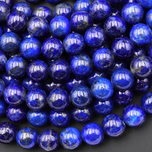 Può includere: Una collana di perle rotonde in lapislazzuli blu scuro con macchie dorate. Le perle sono lisce e lucidate.