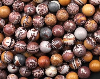 May include: A collection of round, polished beads featuring a variety of natural patterns and colors, including shades of brown, tan, cream, and grey. The beads display marbled textures, speckled details, and smooth, solid-colored surfaces.