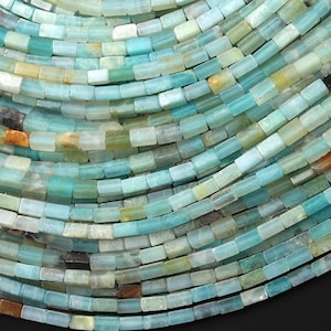 May include: Close-up of small, rectangular beads in shades of blue, green, and tan. The beads are arranged in curved rows, creating a textured, mosaic-like pattern. The overall effect is organic and visually appealing.