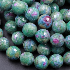 Könnte beinhalten: Eine Kette aus grünen und rosafarbenen Edelsteinperlen. Die Perlen sind facettiert und haben eine raue, natürliche Textur.