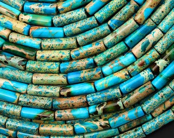 May include: A collection of cylindrical beads featuring a marbled pattern in shades of turquoise, teal, and tan. Each bead displays a smooth, polished surface with unique natural color variations and speckled textures arranged in a dense, curved pattern.