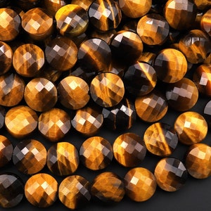 May include: A close-up of a pile of round, faceted tiger's eye beads. The beads are a mix of golden brown and black colors.