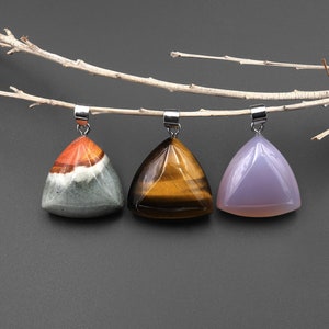May include: Three triangular gemstone pendants with silver bail loops. The pendants are made of tiger's eye, green and red agate, and amethyst.