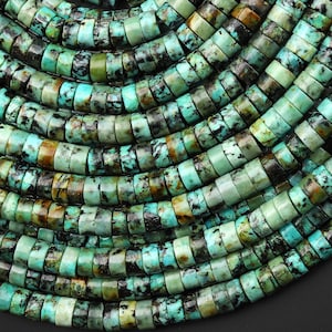 May include: A collection of multiple strands of turquoise-colored stone beads arranged in parallel rows. Each bead is shaped like a small, flat disc with a smooth surface, featuring natural black and brown veining throughout the teal and green stone.