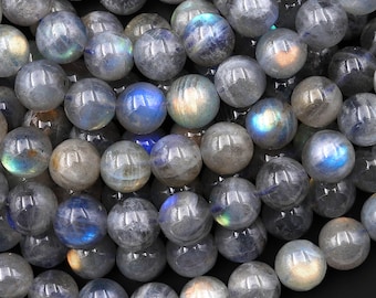 May include: A strand of round, iridescent labradorite beads. The beads are a mix of gray and blue with a shimmery, opalescent finish.