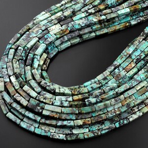 May include: A strand of turquoise gemstone beads, each bead is a rectangular shape with a mottled green, blue, and brown pattern.