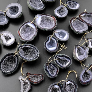 May include: A collection of 16 pairs of earrings featuring natural agate slices with a variety of colors and patterns. The earrings are made with gold-toned metal and have a simple design.