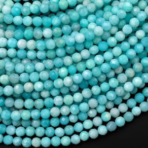 Peut inclure: Un brin de perles de pierre précieuse amazonite bleu turquoise. Les perles sont facettées et de forme ronde. Les perles sont enfilées sur un fil transparent.