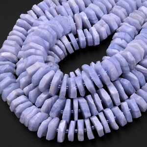 May include: A strand of blue lace agate beads, each bead is faceted and has a unique pattern. The beads are strung on a clear elastic cord.