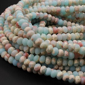 May include: Strands of gemstone beads in shades of pale blue, cream, and reddish-brown. The beads have a matte finish and a slightly irregular shape, creating a natural, earthy look. Ideal for jewelry making.