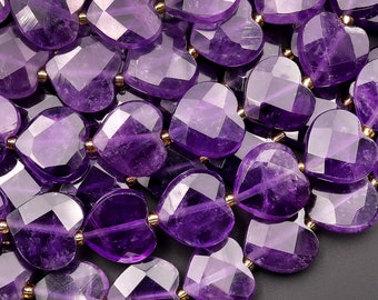 May include: A strand of purple amethyst heart-shaped beads with gold spacers. The beads are faceted and have a shiny, polished finish.