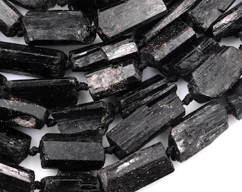 May include: A strand of black tourmaline beads, each bead is a rough, rectangular shape with a natural, matte finish.
